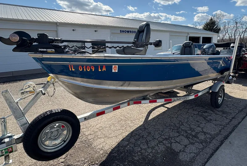 Slide: The Image of 2021 Lund 1600 Fury Tiller boat on trailer, parked outside a showroom. - 5