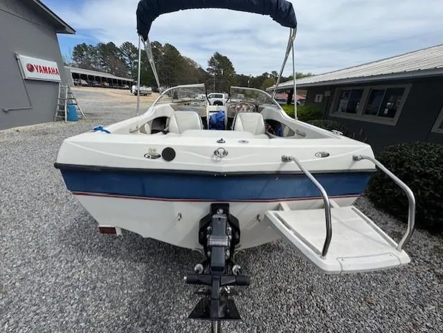 Slide: The Image of 2005 Bayliner 195 Bowrider boat on trailer, parked on gravel near buildings. - 4