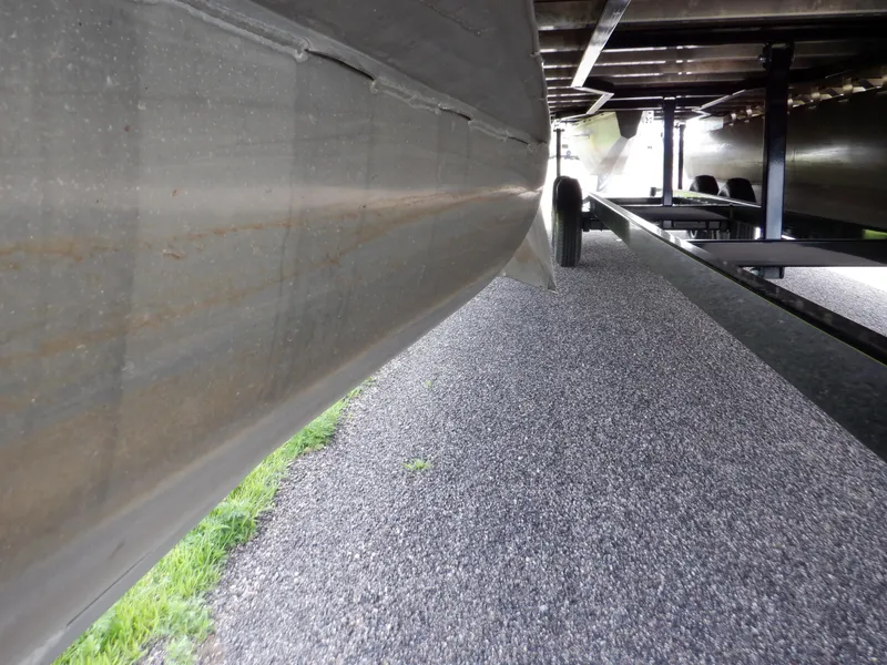 Slide: The Image of Underneath view of a 2013 Harris FloteBote Cruiser 240 on a gravel surface. - 13