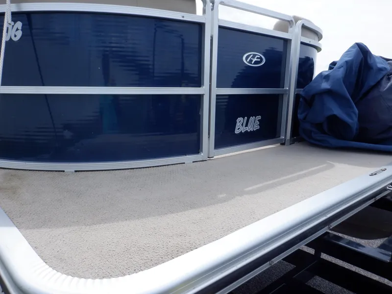 Slide: The Image of 2013 Harris FloteBote Cruiser 240 pontoon boat with blue exterior and carpeted deck. - 14