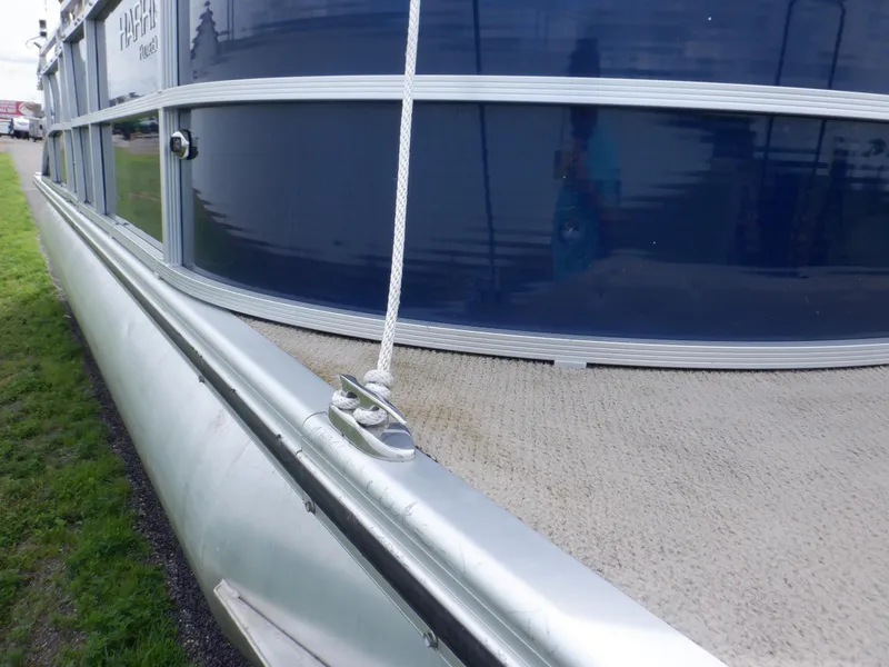 Slide: The Image of 2013 Harris FloteBote Cruiser 240 pontoon boat, side view with blue paneling and rope detail. - 15