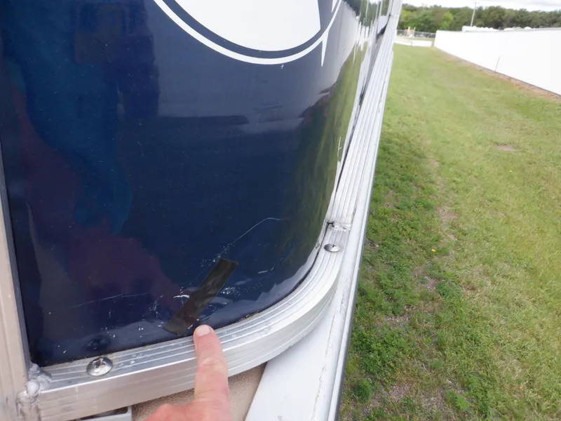 Slide: The Image of 2013 Harris FloteBote Cruiser 240 with minor hull damage, finger pointing at the affected area. - 20