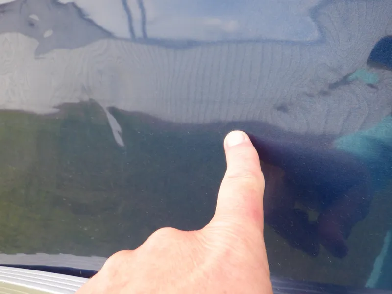 Slide: The Image of Hand pointing at dent on 2013 Harris FloteBote Cruiser 240 boat surface. - 23