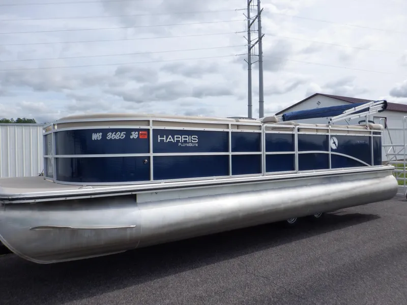 Slide: The Image of 2013 Harris FloteBote Cruiser 240 pontoon boat parked on pavement. - 3