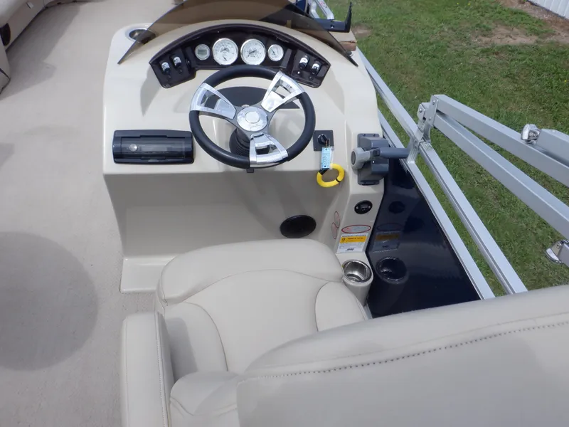 Slide: The Image of 2013 Harris FloteBote Cruiser 240 helm with steering wheel and gauges, beige interior. - 31