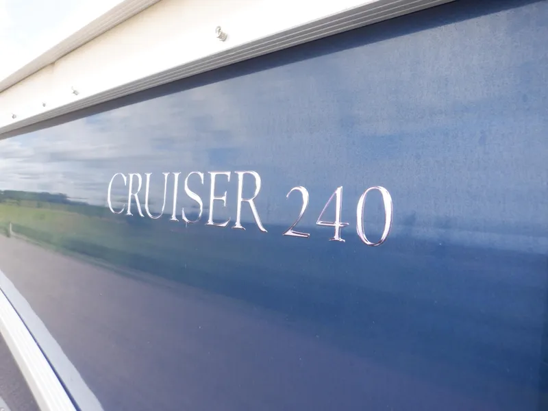 Slide: The Image of 2013 Harris FloteBote Cruiser 240 boat nameplate on blue exterior. - 8