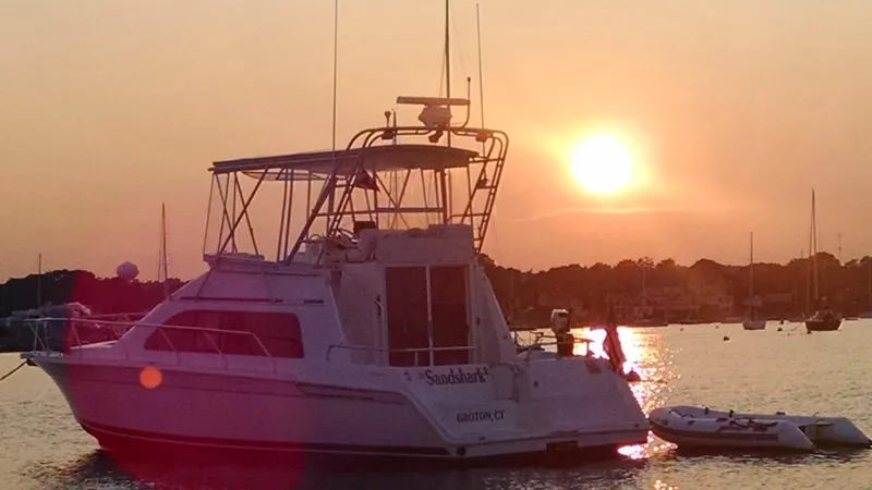 Slide: The Image of 1996 Mainship 40 Sedan Bridge yacht at sunset on tranquil water. - 1