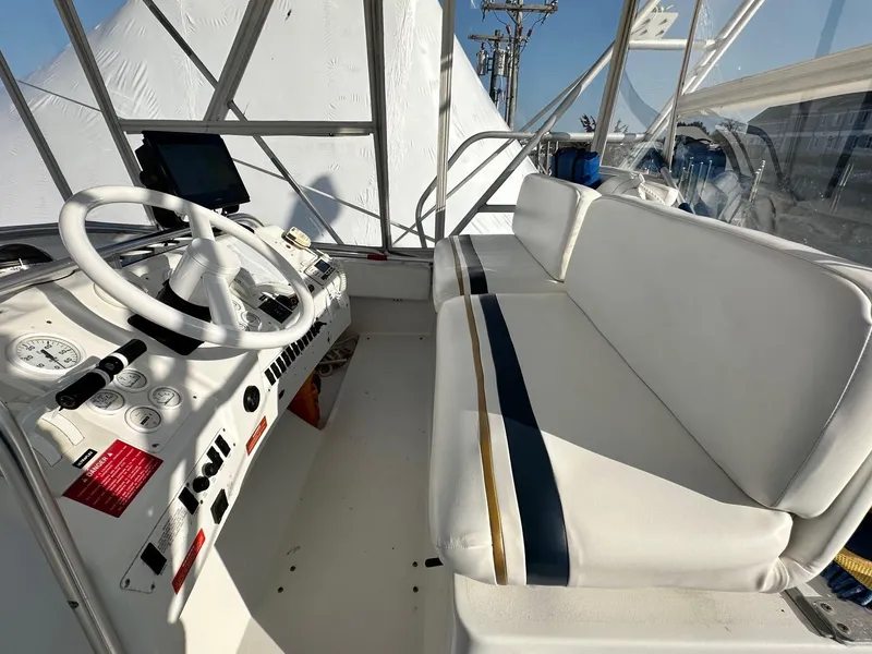 Slide: The Image of 1996 Mainship 40 Sedan Bridge helm with white seating and steering wheel. - 13