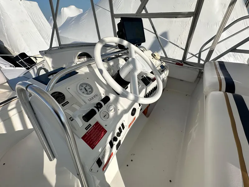 Slide: The Image of 1996 Mainship 40 Sedan Bridge helm with steering wheel and navigation controls. - 14