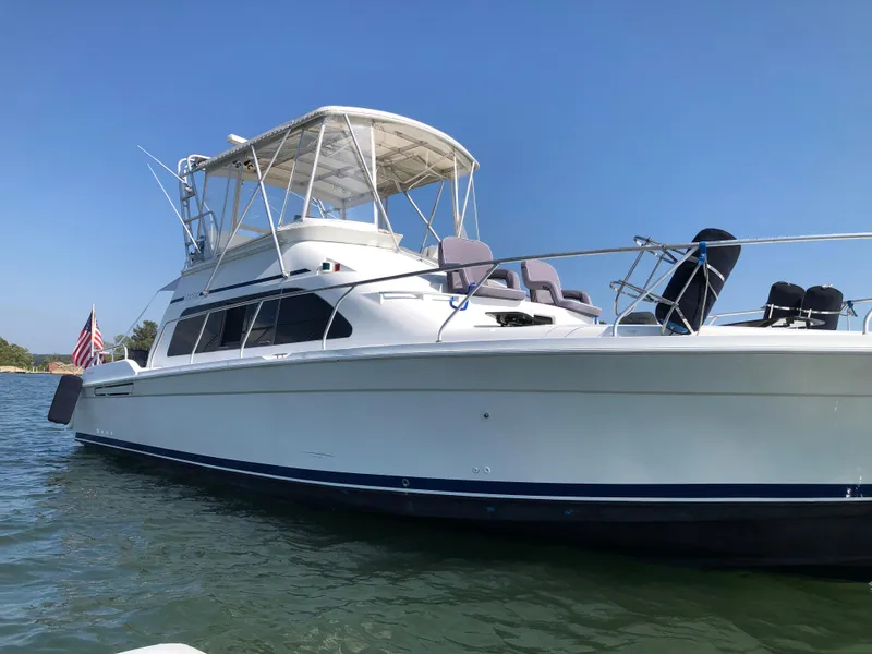 Slide: The Image of 1996 Mainship 40 Sedan Bridge yacht on calm water, clear sky background. - 2