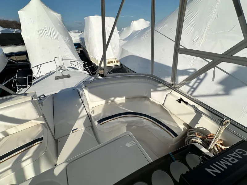 Slide: The Image of 1996 Mainship 40 Sedan Bridge boat, covered in white tarps, docked in a marina. - 20