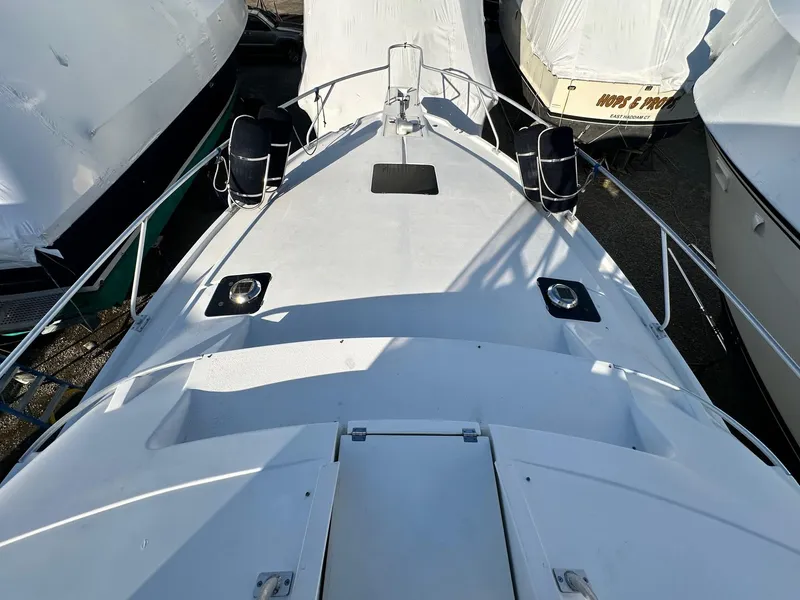 Slide: The Image of 1996 Mainship 40 Sedan Bridge boat deck, surrounded by other covered boats. - 22