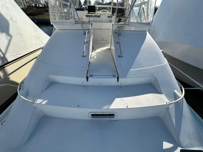 Slide: The Image of 1996 Mainship 40 Sedan Bridge boat deck with steps and railing, docked outdoors. - 27