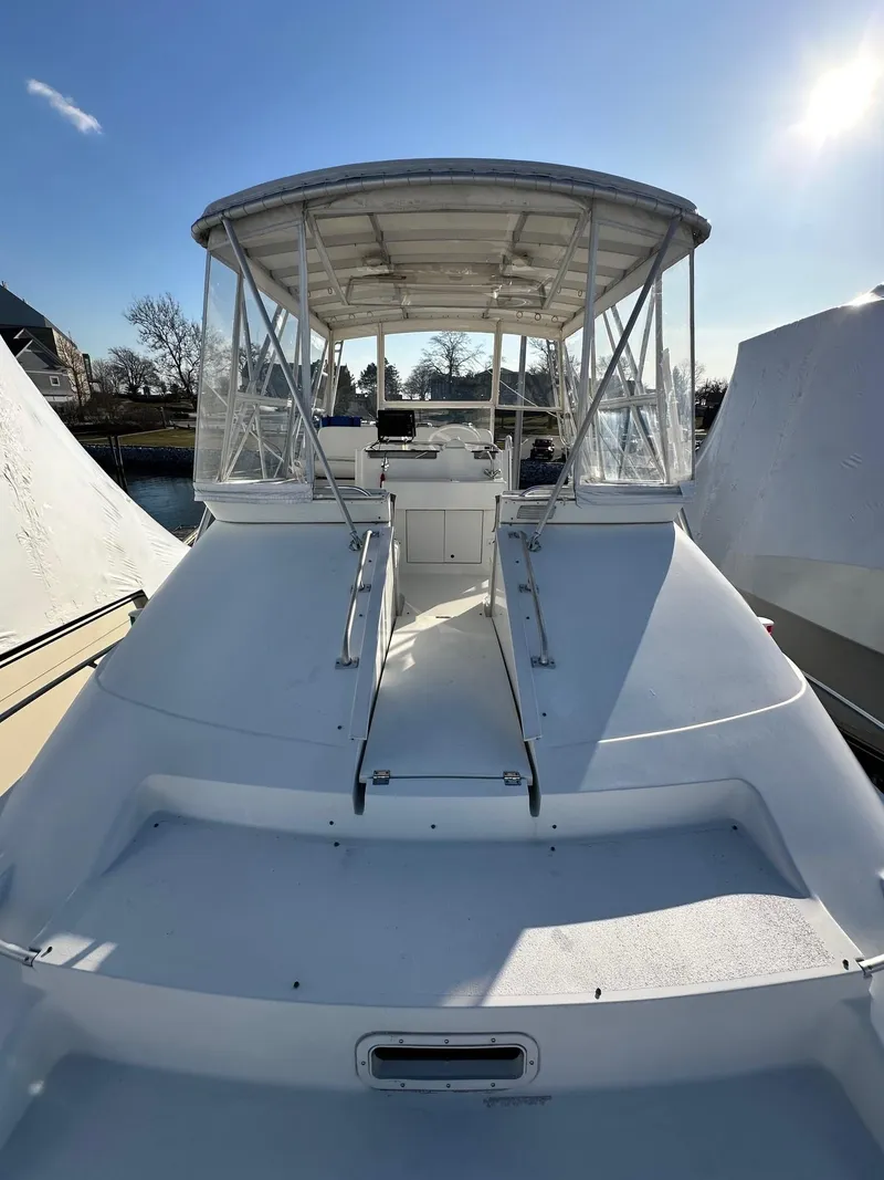 Slide: The Image of 1996 Mainship 40 Sedan Bridge boat with covered helm, docked under clear sky. - 28