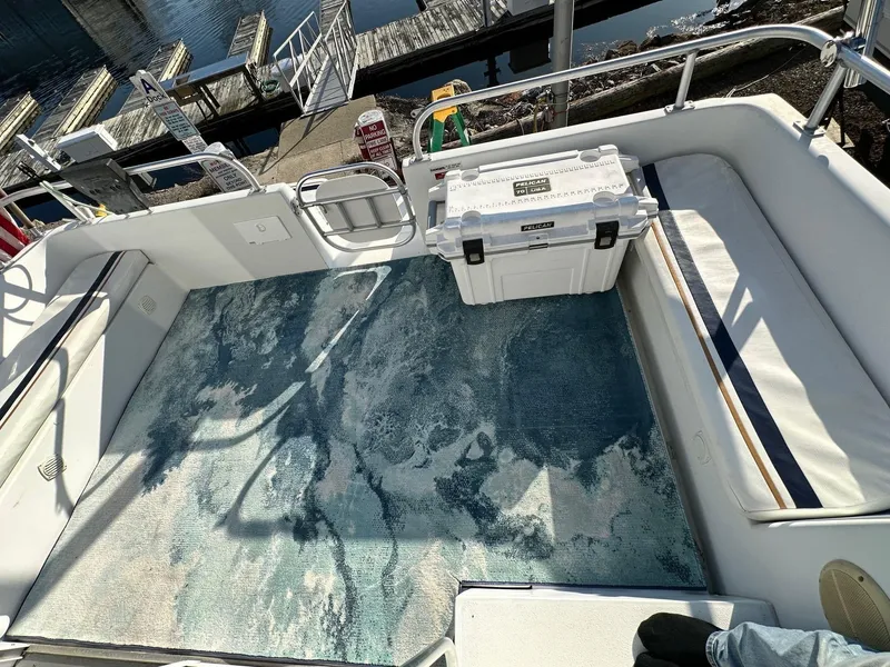 Slide: The Image of 1996 Mainship 40 Sedan Bridge deck with seating, cooler, and patterned rug at marina. - 30