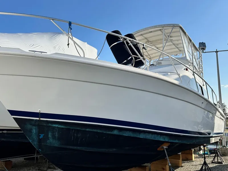 Slide: The Image of 1996 Mainship 40 Sedan Bridge boat on dry dock, side view under clear sky. - 4