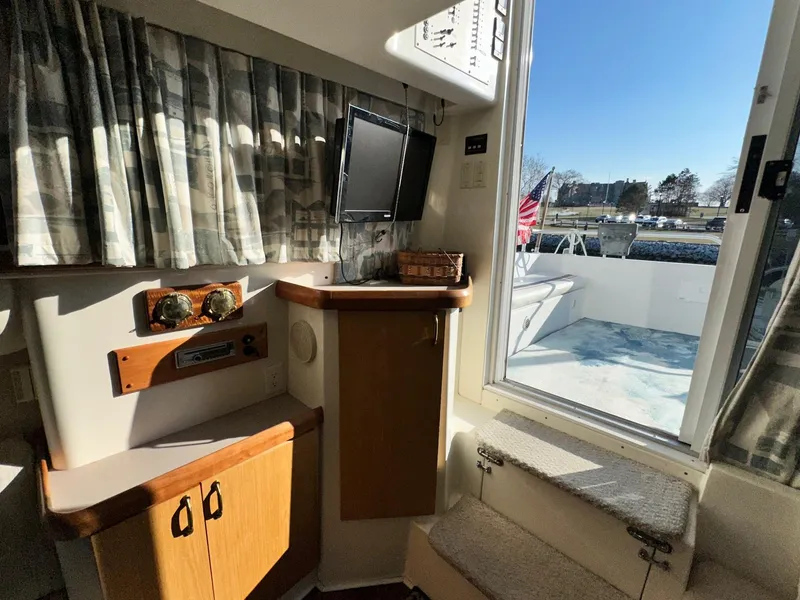Slide: The Image of Interior of 1996 Mainship 40 Sedan Bridge with TV, cabinets, and outdoor view. - 43