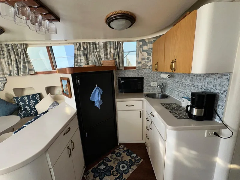 Slide: The Image of 1996 Mainship 40 Sedan Bridge kitchen with cabinets, sink, microwave, and coffee maker. - 46