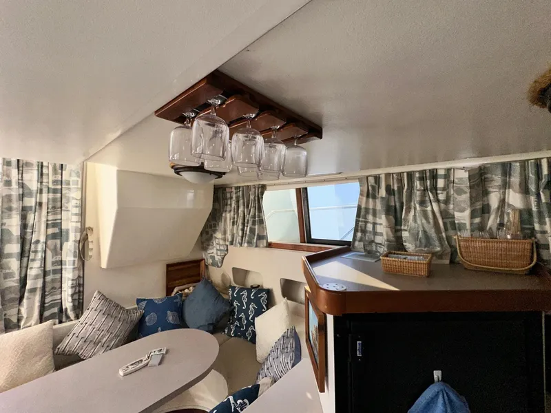 Slide: The Image of Interior of 1996 Mainship 40 Sedan Bridge with cozy seating and glass rack. - 48