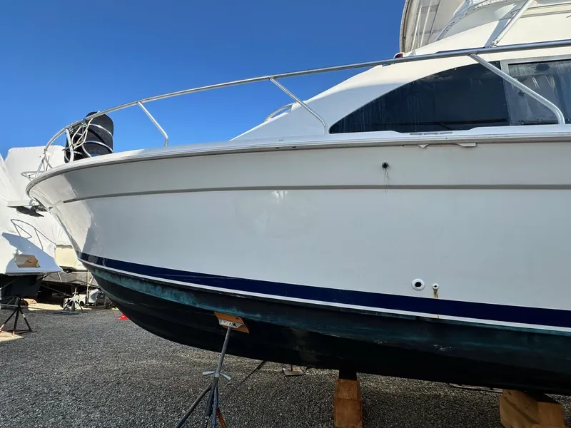 Slide: The Image of 1996 Mainship 40 Sedan Bridge boat on stands, side view under clear blue sky. - 5