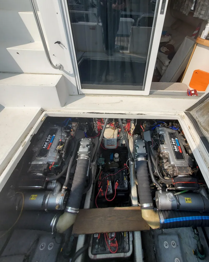 Slide: The Image of Engine compartment of a 1996 Mainship 40 Sedan Bridge, showcasing dual engines and wiring. - 65
