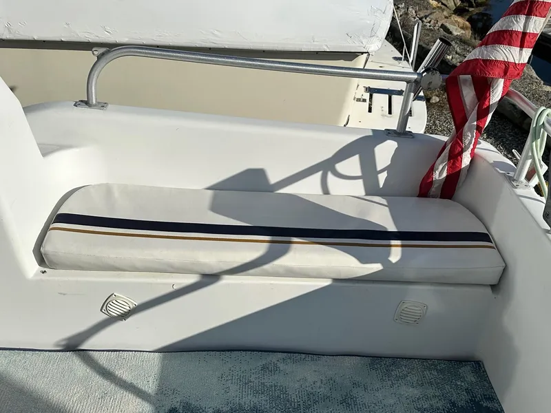 Slide: The Image of 1996 Mainship 40 Sedan Bridge boat seating area with striped cushion and American flag. - 7