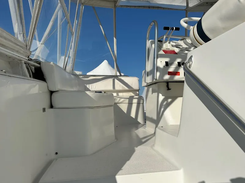 Slide: The Image of 1996 Mainship 40 Sedan Bridge helm with white seating and controls under clear blue sky. - 9