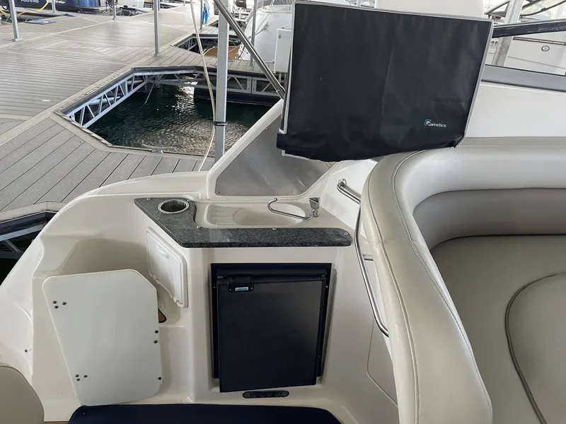 Slide: The Image of 2005 Regal 2860 Express Cruiser interior with seating, mini fridge, and sink. - 12