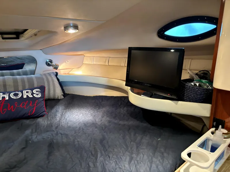 Slide: The Image of 2005 Regal 2860 Express Cruiser cabin with bed, TV, and nautical decor. - 13