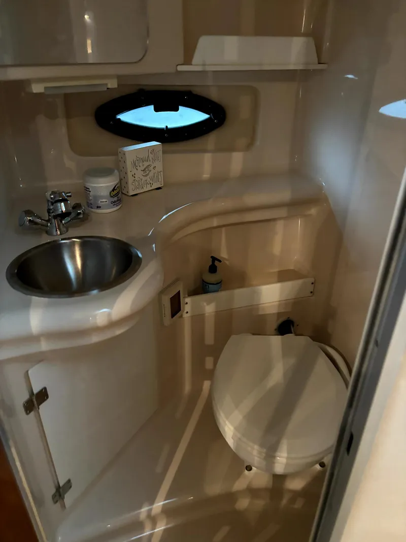 Slide: The Image of 2005 Regal 2860 Express Cruiser bathroom with sink, toilet, and porthole window. - 19