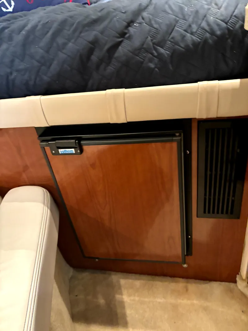 Slide: The Image of 2005 Regal 2860 Express Cruiser interior with wood paneling and compact fridge. - 20