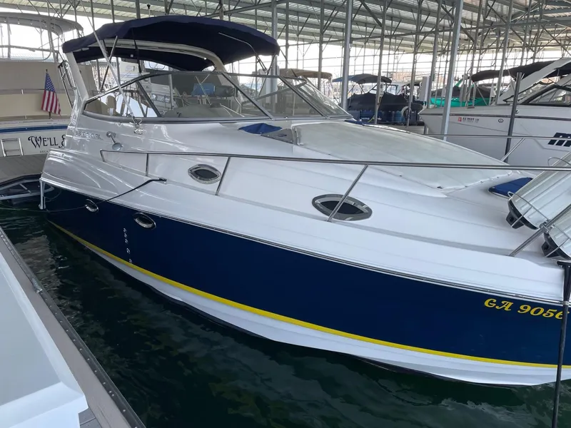 Slide: The Image of 2005 Regal 2860 Express Cruiser docked in a marina, featuring a sleek blue and white design. - 6