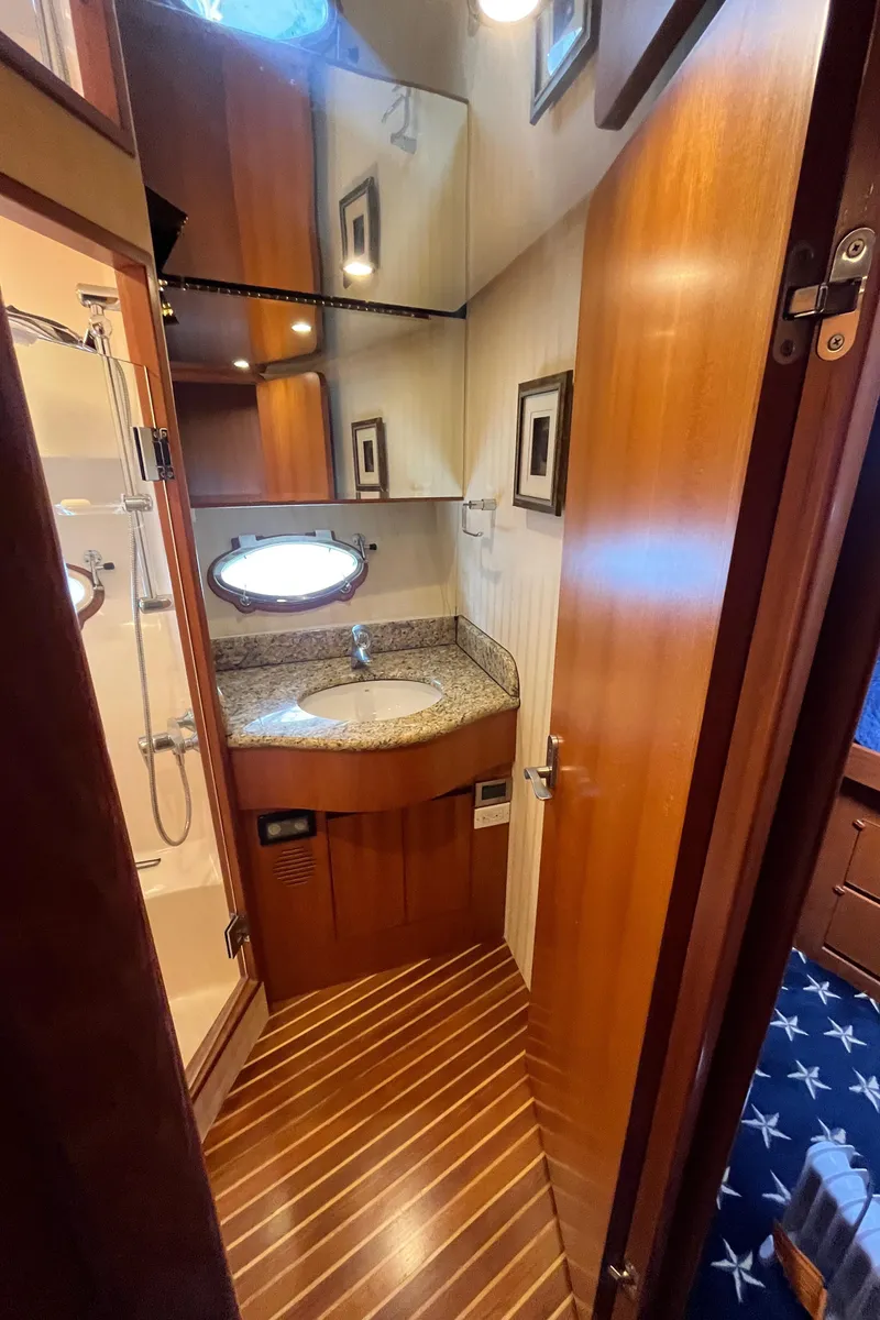 Slide: The Image of 2005 Ocean Alexander 52 Sedan bathroom with wood accents and modern fixtures. - 16