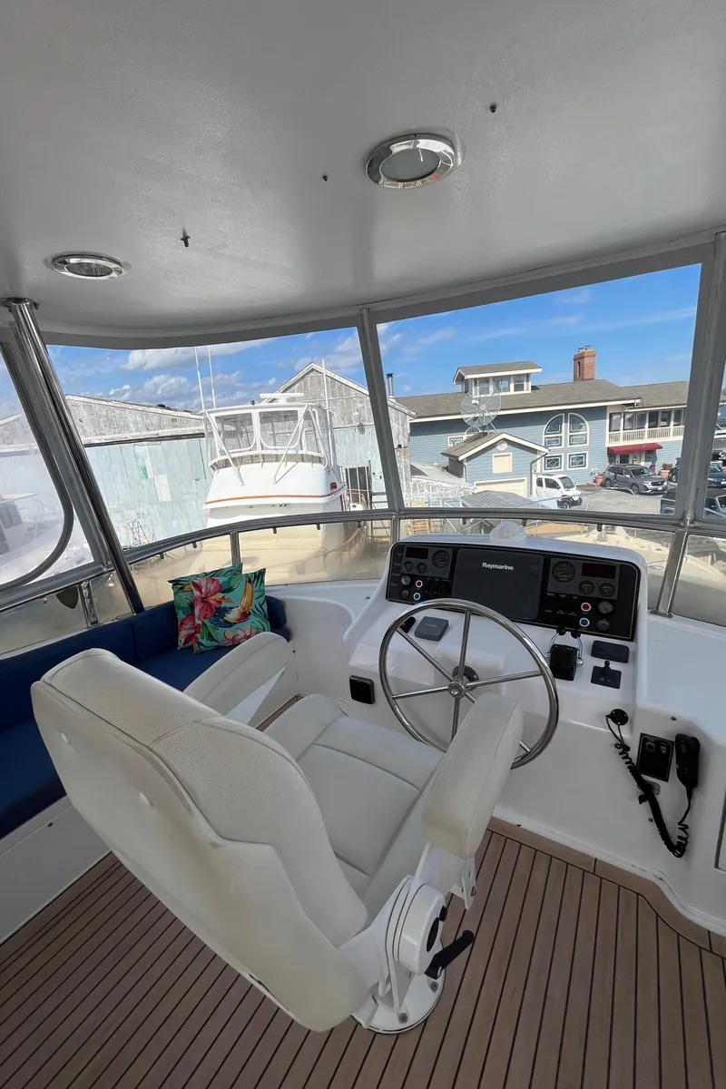 Slide: The Image of 2005 Ocean Alexander 52 Sedan helm with white captain's chair and panoramic windows. - 18