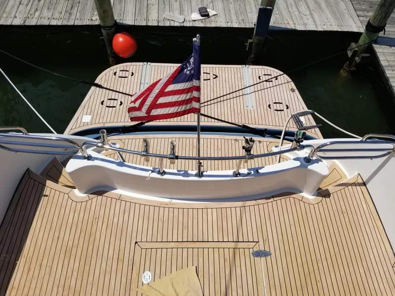 Slide: The Image of 2005 Ocean Alexander 52 Sedan yacht with American flag, docked at marina. - 25