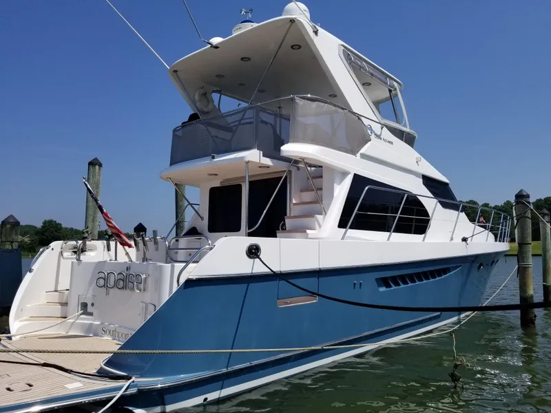 Slide: The Image of 2005 Ocean Alexander 52 Sedan yacht docked, featuring sleek design and blue hull. - 26