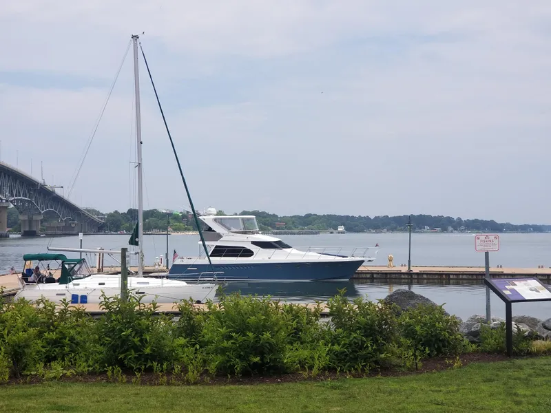 Slide: The Image of 2005 Ocean Alexander 52 Sedan yacht docked by a scenic waterfront with greenery. - 27
