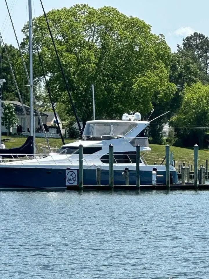 Slide: The Image of 2005 Ocean Alexander 52 Sedan yacht docked by lush greenery. - 3