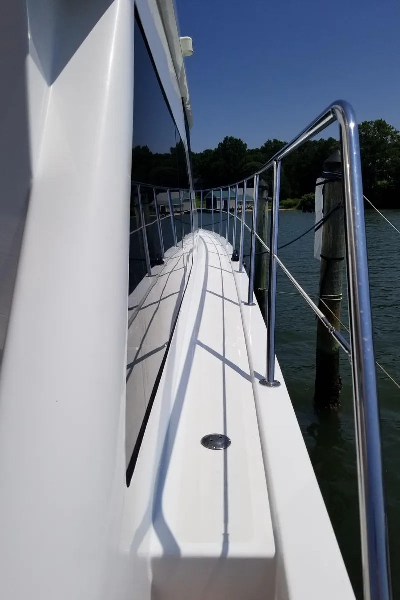 Slide: The Image of 2005 Ocean Alexander 52 Sedan yacht deck with railing, reflecting water and sky. - 30