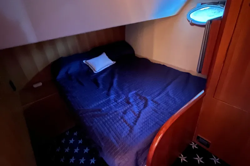 Slide: The Image of Cozy bedroom in 2005 Ocean Alexander 52 Sedan yacht with blue bedding and porthole. - 31
