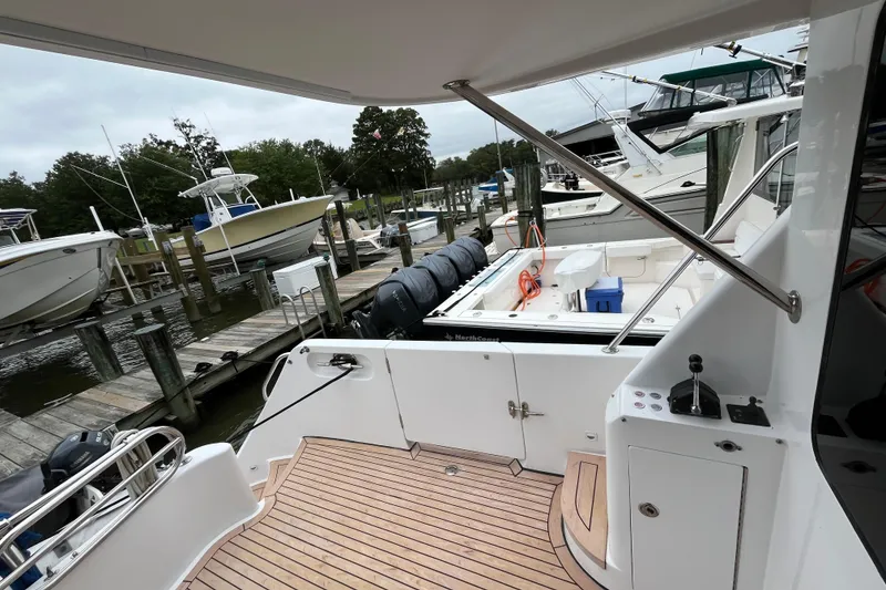 Slide: The Image of 2005 Ocean Alexander 52 Sedan yacht docked at marina with wooden deck and nearby boats. - 35