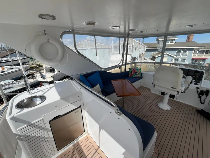 Slide: The Image of 2005 Ocean Alexander 52 Sedan yacht interior with seating, table, and helm station. - 6