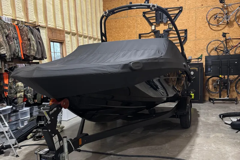 Slide: The Image of 2024 Yamaha Boats 195S covered in a garage, surrounded by outdoor gear and bicycles. - 10