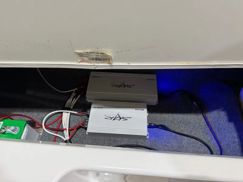 Slide: The Image of 2024 Yamaha Boats 195S audio system wiring and amplifiers in storage compartment. - 12