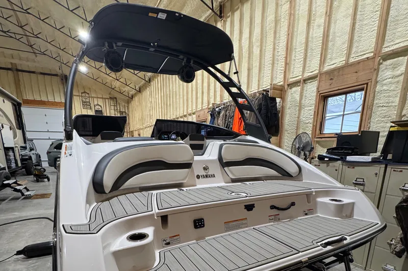 Slide: The Image of 2024 Yamaha Boats 195S in a garage, showcasing its sleek design and spacious seating. - 3