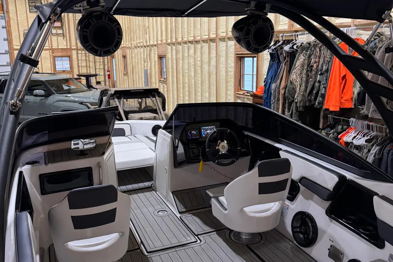 Slide: The Image of 2024 Yamaha Boats 195S interior with modern dashboard and seating in a showroom. - 4