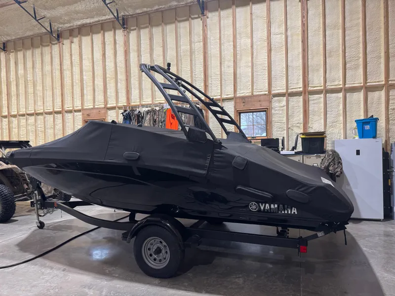 Slide: The Image of 2024 Yamaha Boats 195S covered in a garage, showcasing sleek design and trailer. - 9
