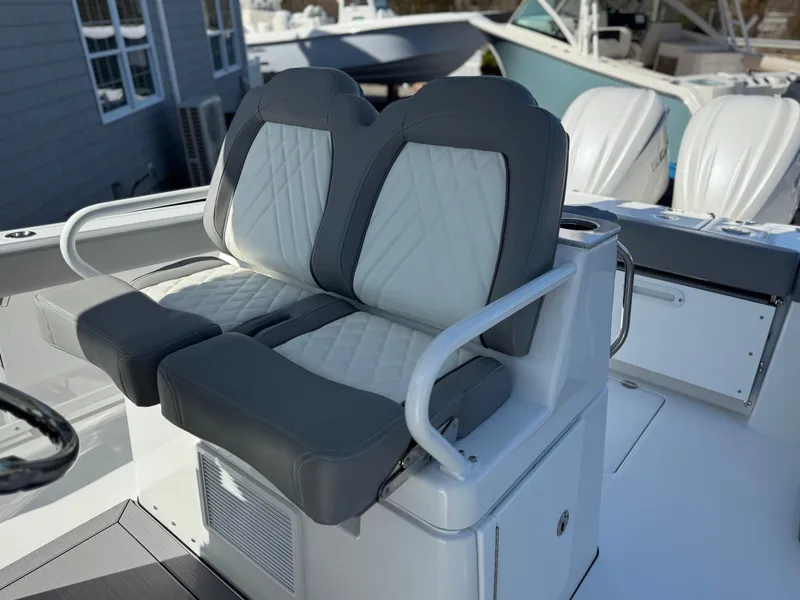 Slide: The Image of 2025 Everglades 285 Center Console boat seats with gray and white upholstery. - 16