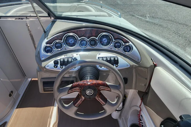 Slide: The Image of 2008 Crownline 240LS boat dashboard with gauges and wood-accented steering wheel. - 10