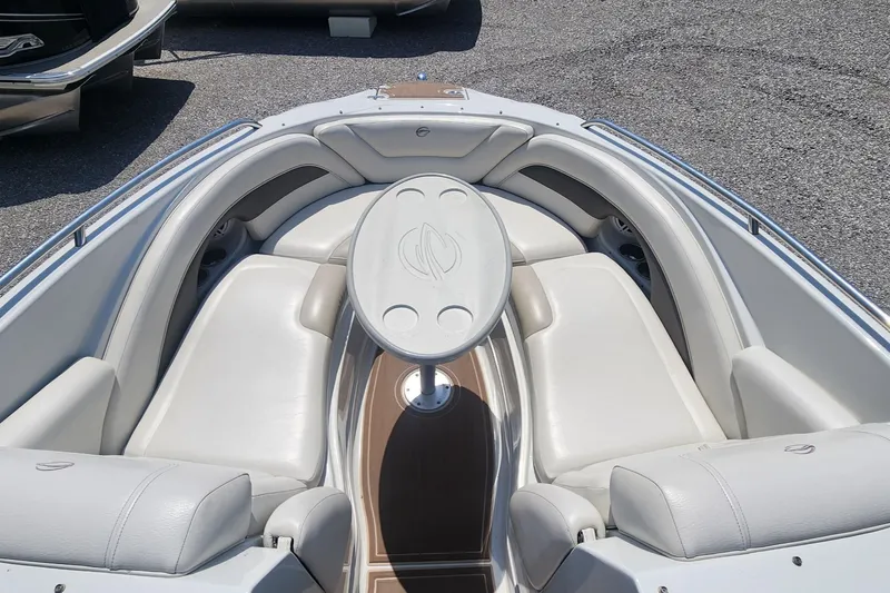 Slide: The Image of 2008 Crownline 240LS boat interior with white seating and oval table. - 12